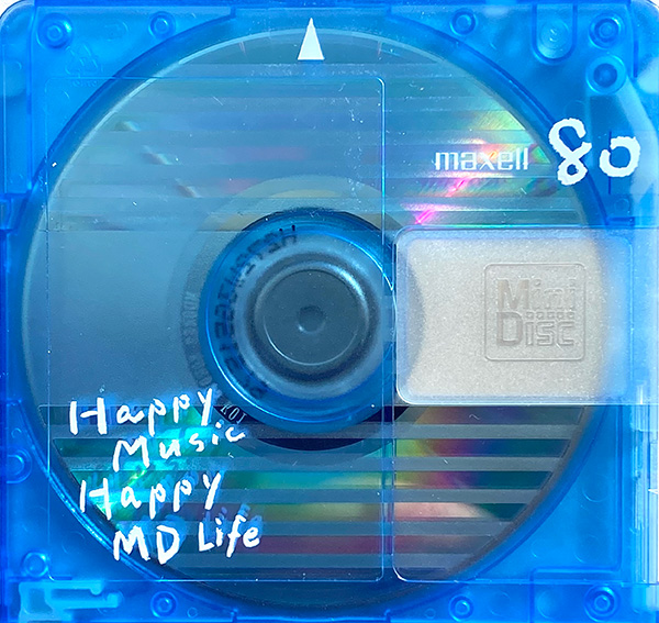 Blue Maxell 80 minidisc with textured stripe pattern and translucent back and label "Happy Music Happy MD Life"